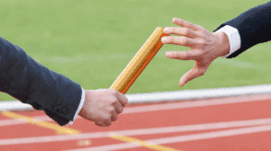 Przekazanie pałeczki w sztafecie widok na same ręce przekazujące pałeczkę