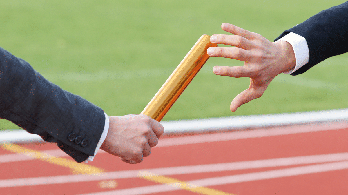 Przekazanie pałeczki w sztafecie widok na same ręce przekazujące pałeczkę