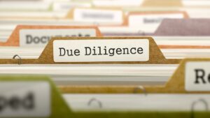 Zakładki z dokumentami, na pierwszym planie oznaczenie „Due Diligence”, symbolizujące analizę transakcji M&A oraz ocenę wpływu wskaźnika POLSTR na finansowanie i warunki transakcyjne.